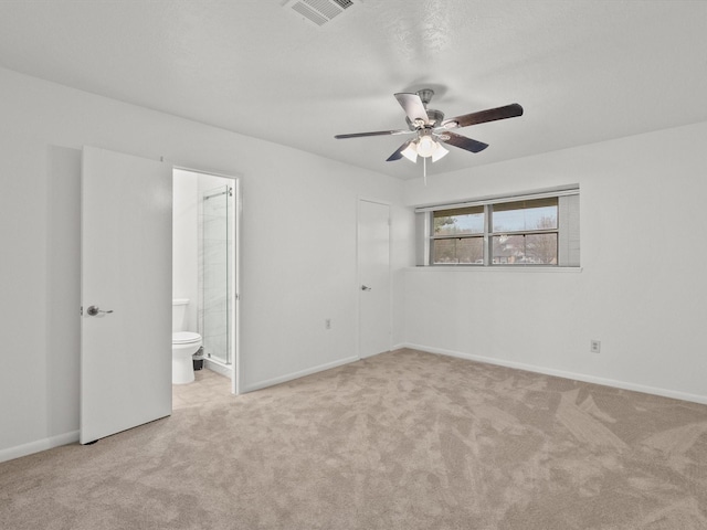 unfurnished bedroom featuring light carpet, ensuite bath, and ceiling fan