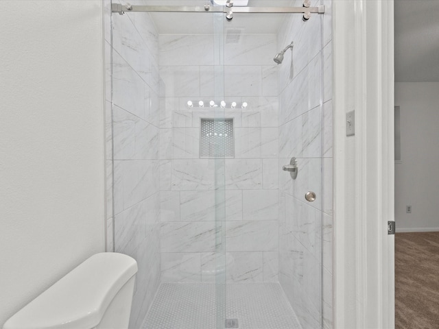 bathroom with a shower with shower door and toilet