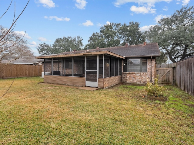 back of house with a sunroom and a yard