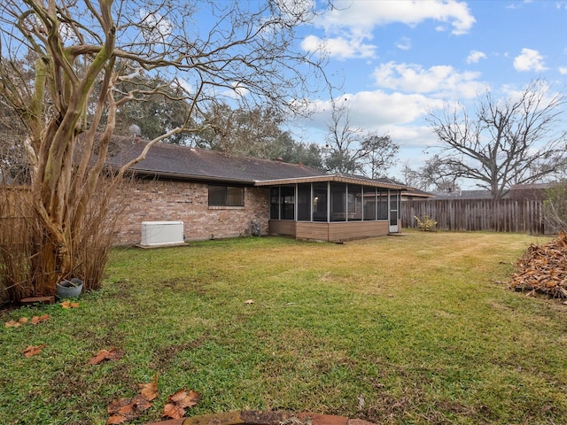 rear view of property featuring a sunroom and a yard