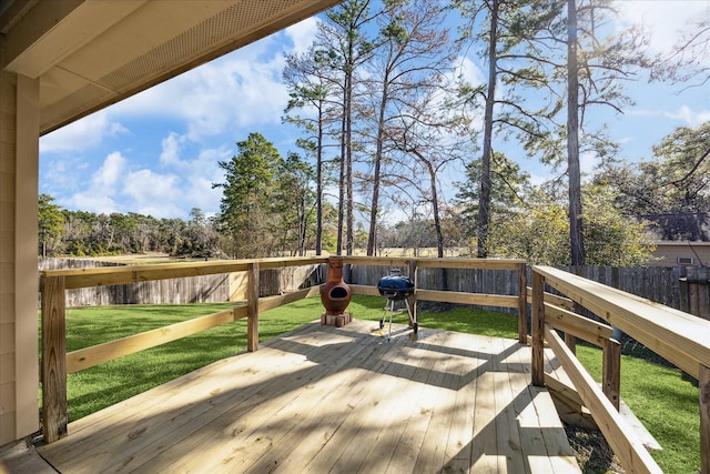 wooden deck with area for grilling, a lawn, and a water view