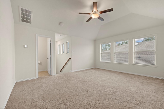 empty room featuring ceiling fan, lofted ceiling, and light carpet