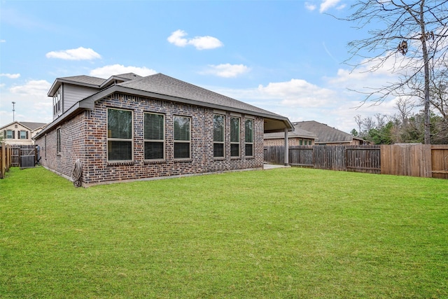 rear view of house featuring central AC and a lawn