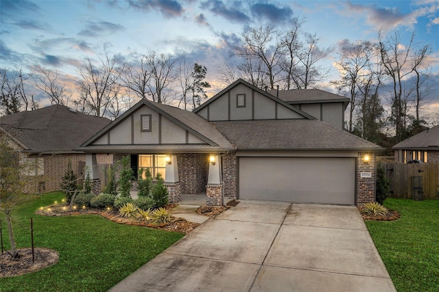 english style home featuring a yard and a garage