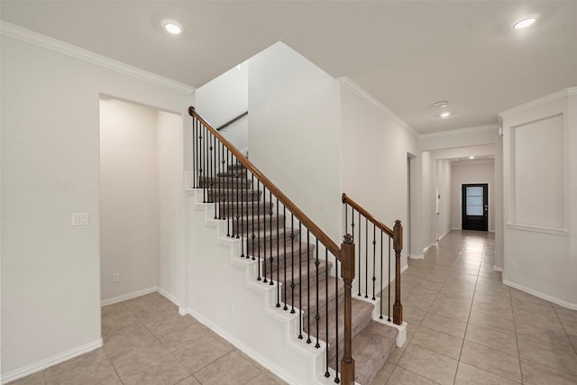 stairway with crown molding and tile patterned floors