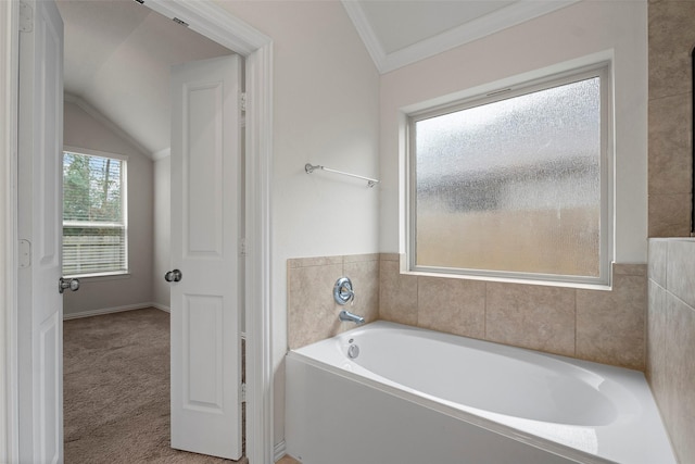 bathroom with a washtub, vaulted ceiling, and ornamental molding