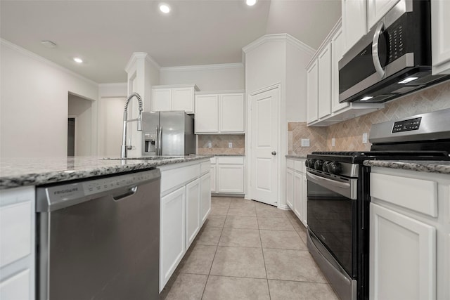 kitchen featuring light stone countertops, white cabinetry, appliances with stainless steel finishes, and light tile patterned floors