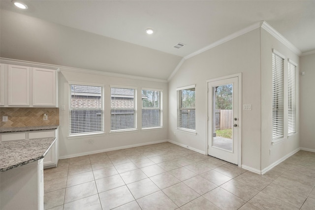 doorway to outside featuring lofted ceiling, light tile patterned floors, and crown molding