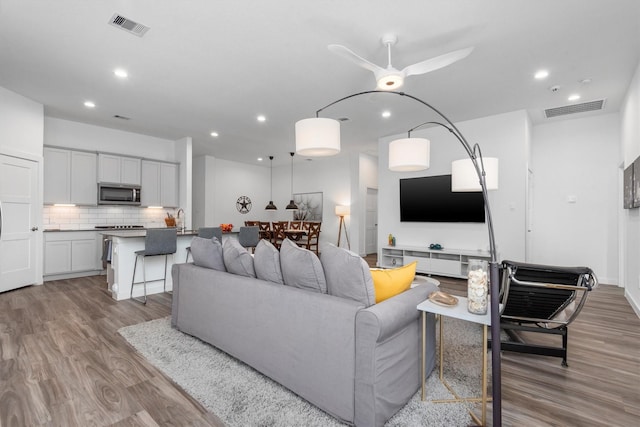 living room featuring ceiling fan and light hardwood / wood-style flooring