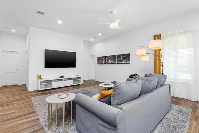 living room featuring wood-type flooring and ceiling fan