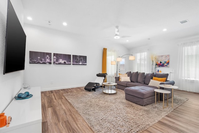 living room featuring light hardwood / wood-style flooring, a wealth of natural light, lofted ceiling, and ceiling fan