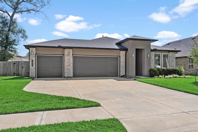 prairie-style home with a garage and a front lawn