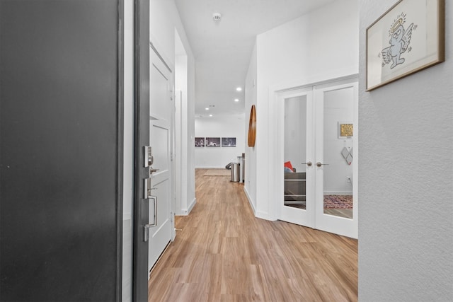 hallway featuring light hardwood / wood-style floors and french doors