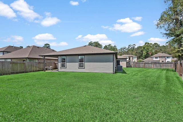 back of property featuring a lawn and central air condition unit