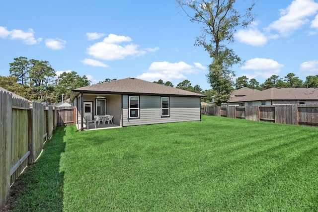 rear view of house with a patio and a lawn