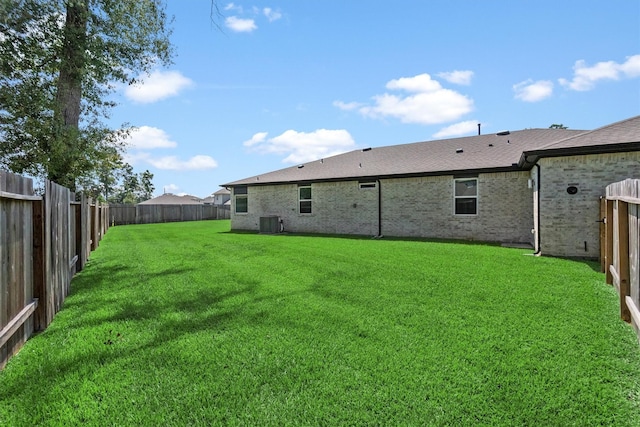 back of house featuring a yard and central air condition unit