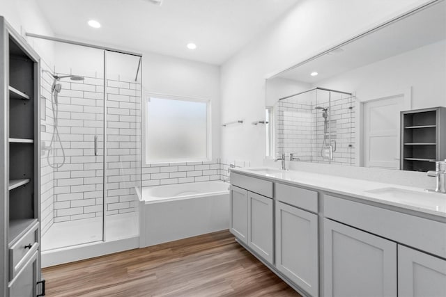 bathroom featuring hardwood / wood-style flooring, vanity, and shower with separate bathtub