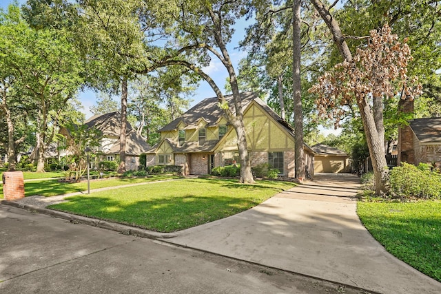 tudor home featuring a garage and a front lawn