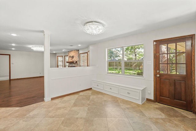 interior space featuring decorative columns and light tile patterned flooring