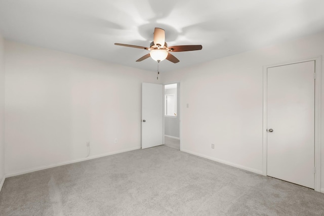 spare room featuring light colored carpet and ceiling fan