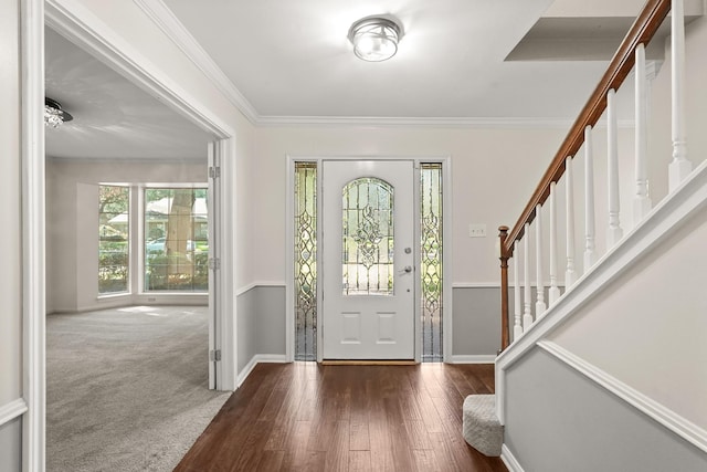 foyer entrance with ornamental molding and dark hardwood / wood-style floors