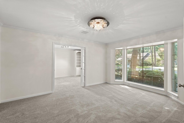 carpeted empty room with an inviting chandelier and ornamental molding