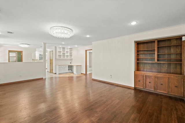 unfurnished living room featuring an inviting chandelier and hardwood / wood-style floors