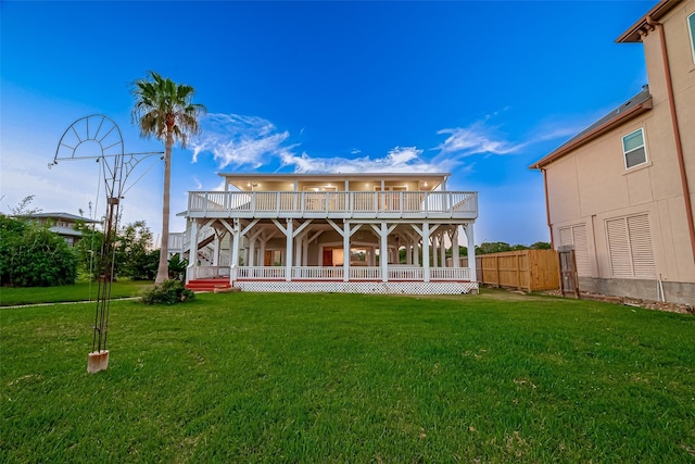 back of house featuring a balcony, covered porch, and a lawn