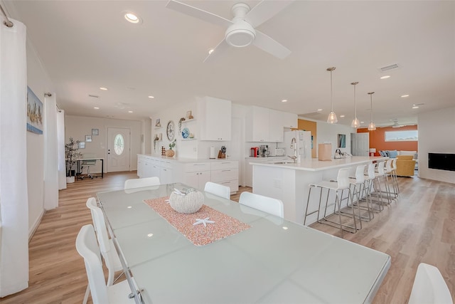 dining space with ceiling fan and light hardwood / wood-style floors