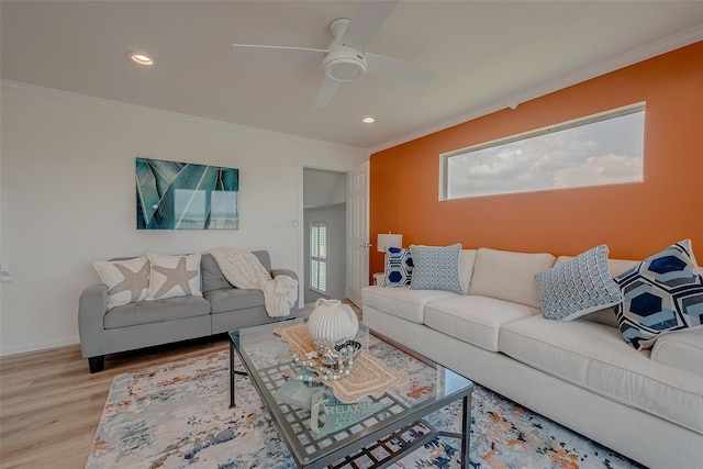 living room featuring ornamental molding, light hardwood / wood-style floors, and ceiling fan