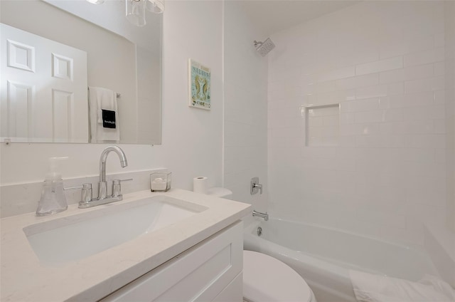 full bathroom with vanity, tiled shower / bath combo, and toilet