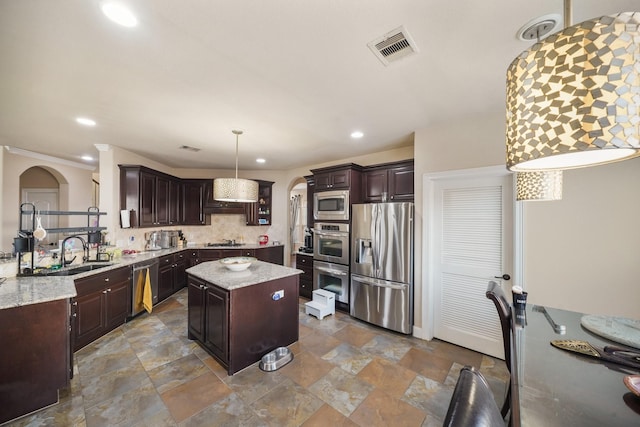 kitchen featuring sink, a center island, dark brown cabinets, hanging light fixtures, and stainless steel appliances