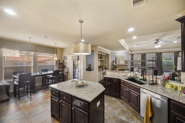 kitchen with decorative light fixtures, sink, a center island, stainless steel dishwasher, and dark brown cabinets