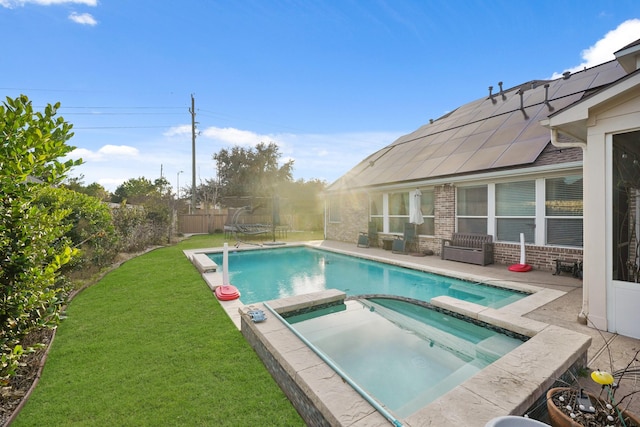 view of pool with an in ground hot tub and a yard