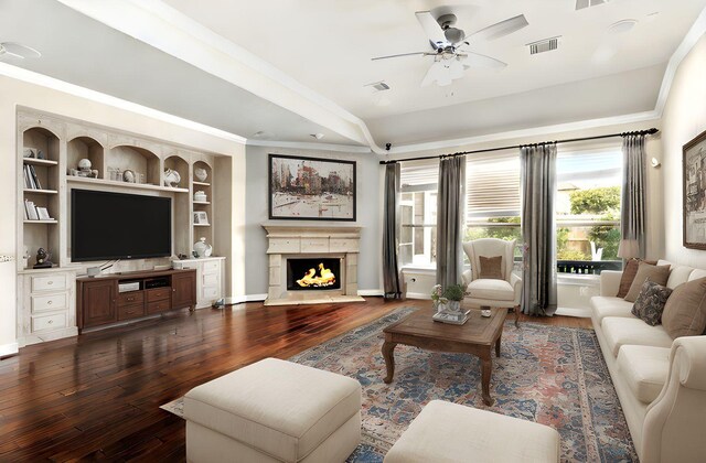 4715 Cedarfield Rd, Katy, TX 77494 - living area with dark wood-type flooring, a ceiling fan, ornamental molding, a warm lit fireplace, and baseboards
