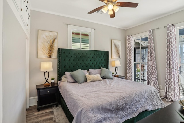 bedroom featuring baseboards, multiple windows, visible vents, and wood finished floors