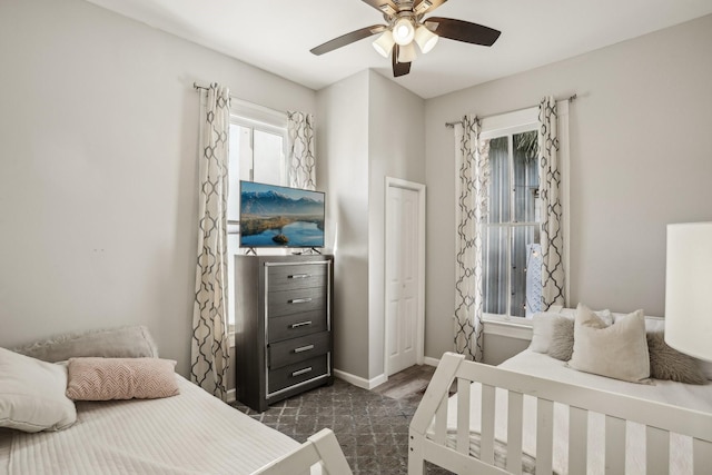 bedroom with a ceiling fan and baseboards