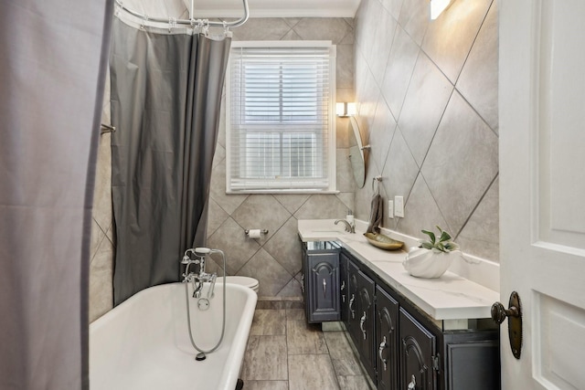 bathroom with a shower with shower curtain, a soaking tub, tile walls, and vanity