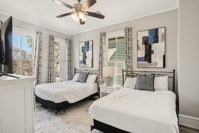 bedroom with ceiling fan, ornamental molding, wood finished floors, and visible vents