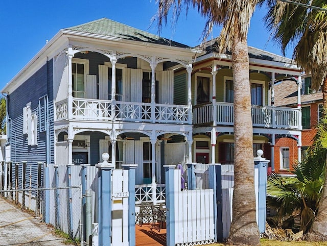 view of front facade featuring covered porch, fence, and a gate