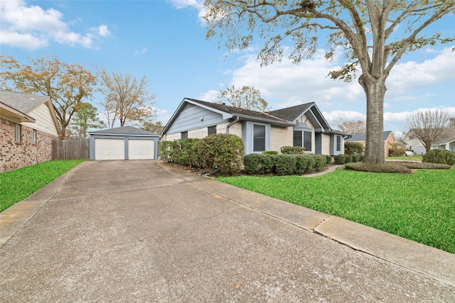 view of front of home featuring an outbuilding, a garage, and a front yard