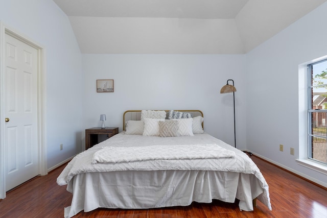 bedroom with dark wood-type flooring and vaulted ceiling