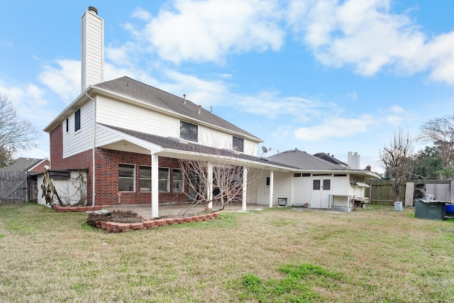 rear view of property with a yard, a patio, and a garage