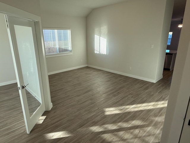 spare room with vaulted ceiling and dark hardwood / wood-style floors