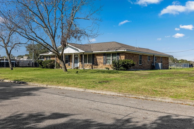 ranch-style home with central AC unit and a front yard