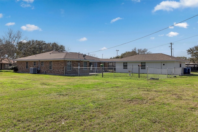 rear view of property with cooling unit and a lawn