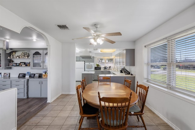 tiled dining space with sink and ceiling fan