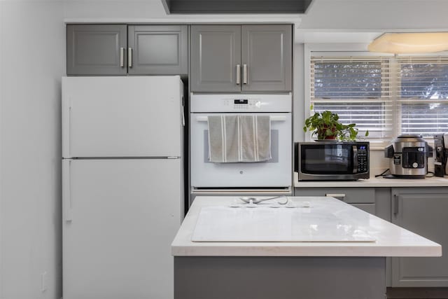 kitchen featuring gray cabinetry and white appliances