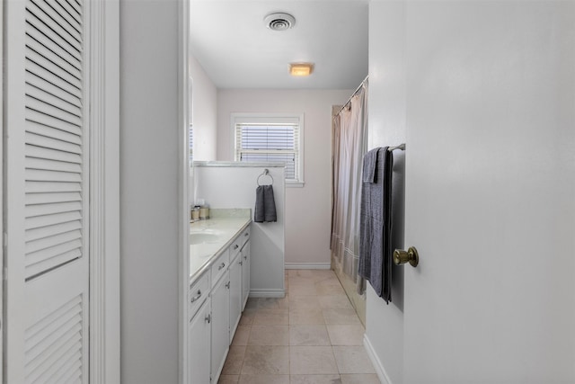 bathroom featuring vanity, tile patterned floors, and walk in shower