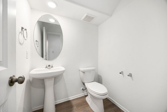 bathroom with hardwood / wood-style floors and toilet